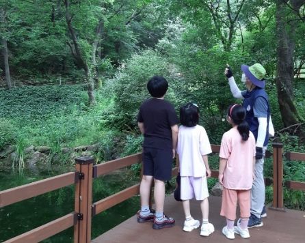 용인자연휴양림 숲해설프로그램 참가자들이 야생화단지 산책로에서 설명을 듣고 있다.