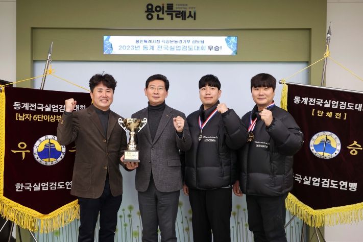 이상일 용인특례시장이 14일 동계 전국실업검도대회에서 우승한 시 검도팀에게 우승기를 전달받고 기념촬영을 하고 있다