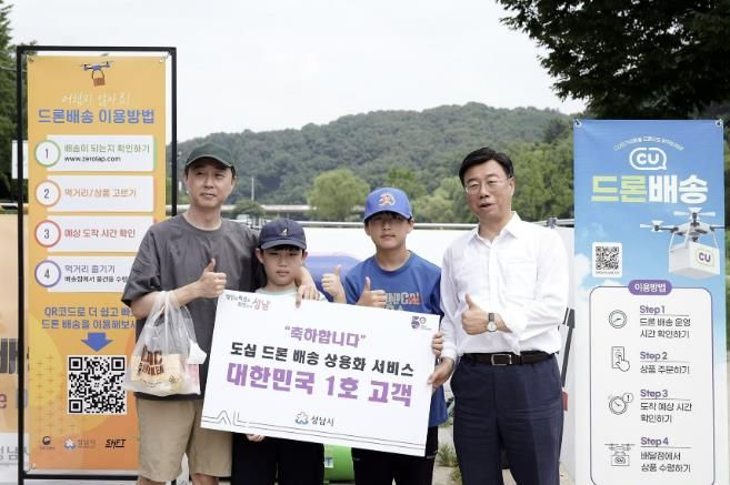 신상진 성남시장이 2023년 드론 배송 상용화서비스 1호 고객과 기념사진을 찍고 있다.