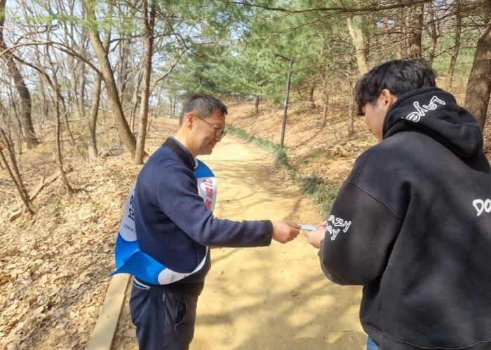 고양시 일산공원관리과 직원이 산불 예방 홍보물을 시민에게 전달하고 있다.