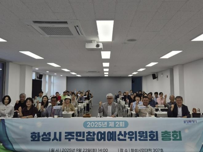 23일 열린 2025년 제2회 화성시주민참여예산위원회 총회에 참석한 위원들이 기념촬영을 하고 있다