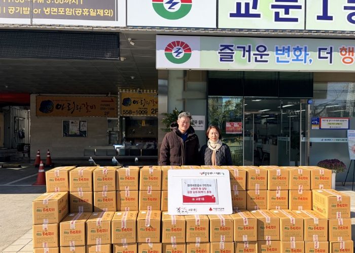 교문1동 이진수 동장과 한국석유공사 구리지사 이은규 팀장이 후원받은 김치 앞에서 포즈를 취하고 있다.